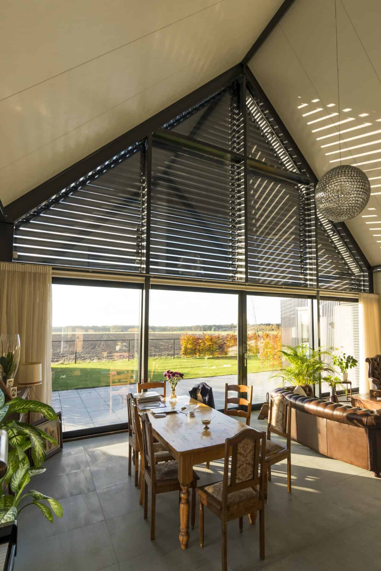 Binnenzijde van moderne loft met in het puntraam kantelbare lamellen