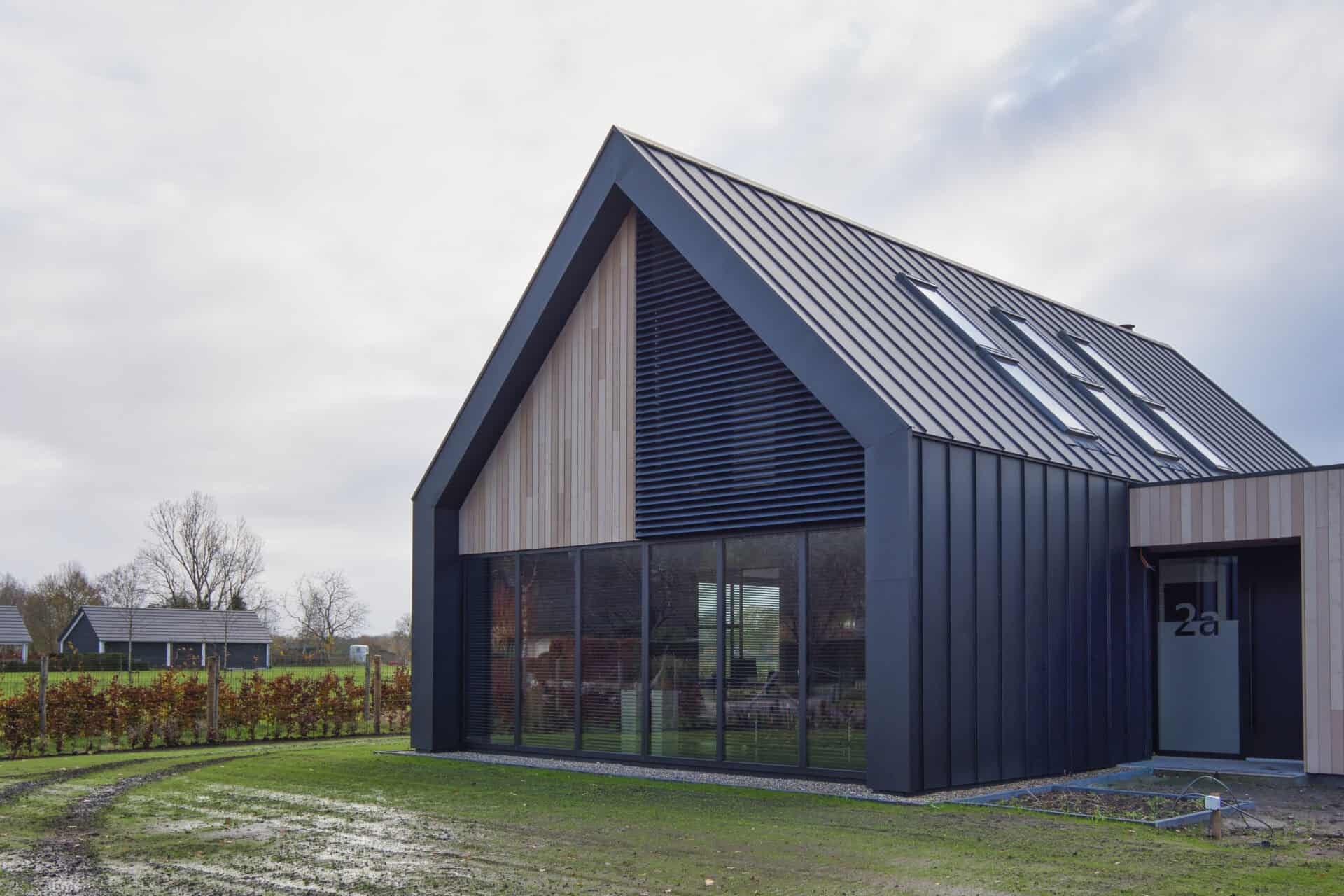 Loft woning met kantelbare lamellen in puntraam met daarnaast houten wandbekleding