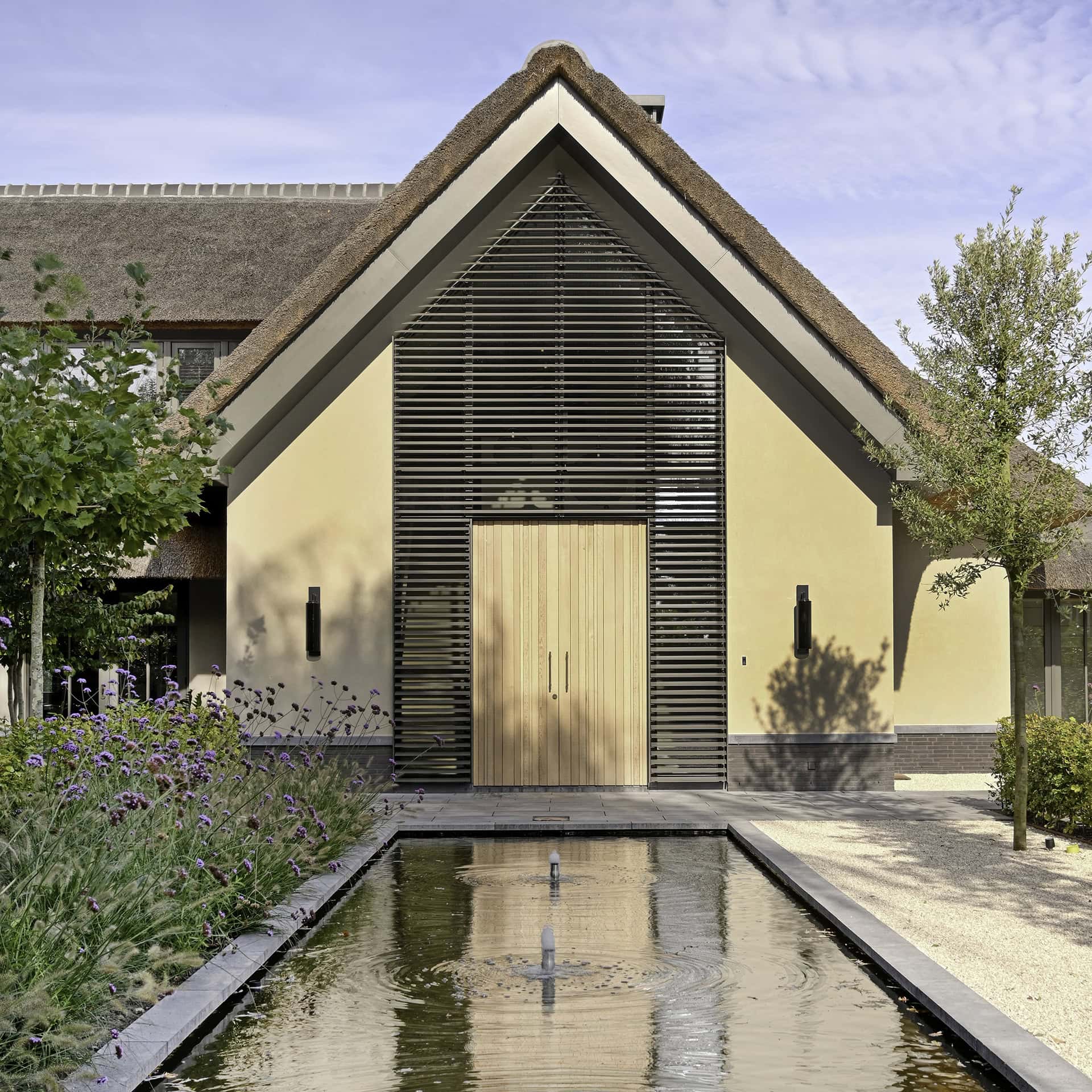 Landelijke villa met kantelbare lamellen tot in de nok om en rond de voordeur