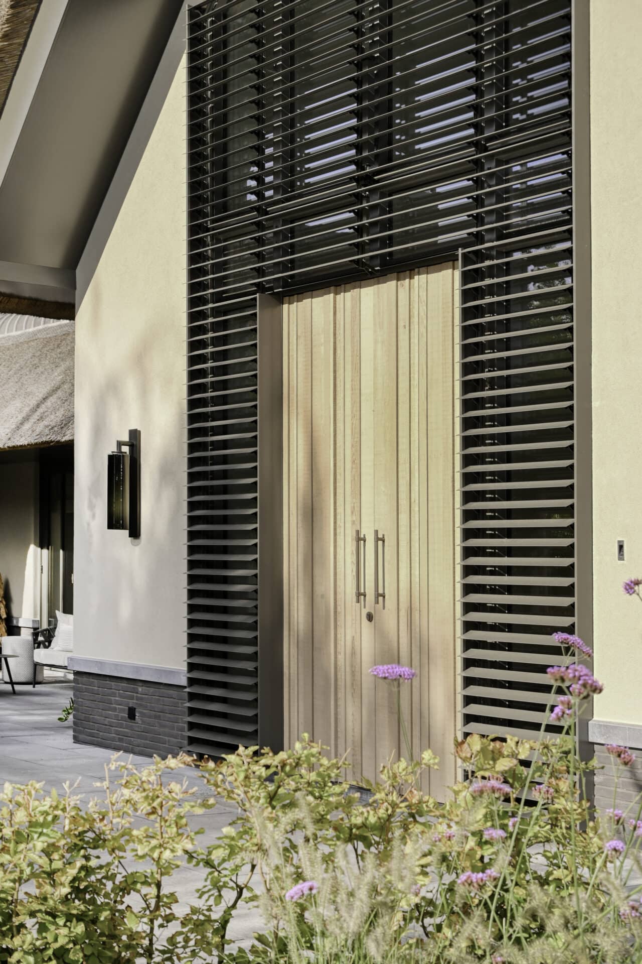 Close-up van landelijke villa met kantelbare lamellen tot in de nok om en rond de voordeur