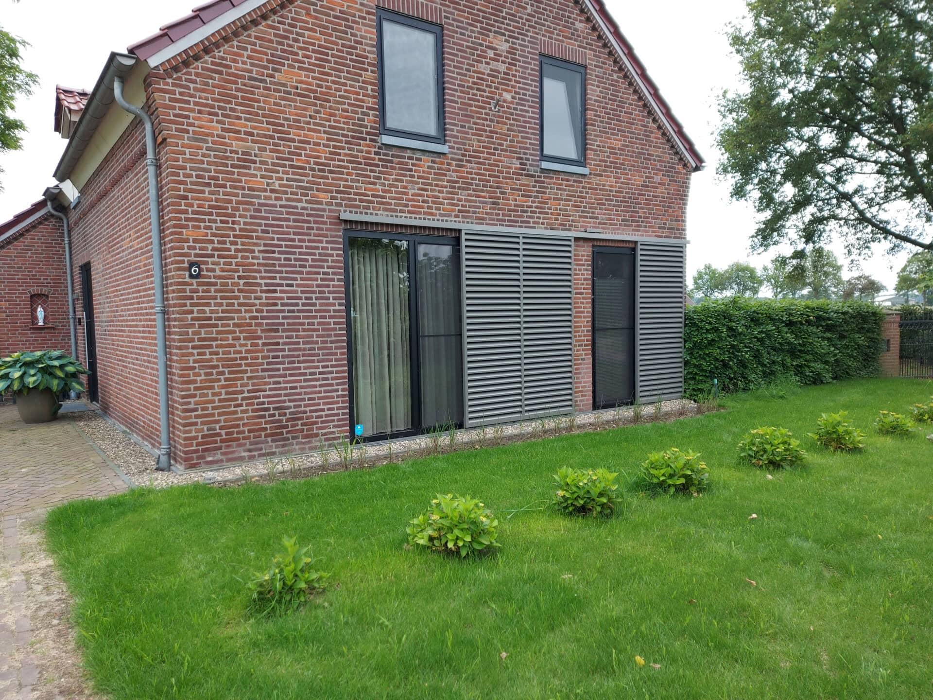 Klassieke woning met schuifpanelen met vaste lamellen aan de gevel, voor het raam