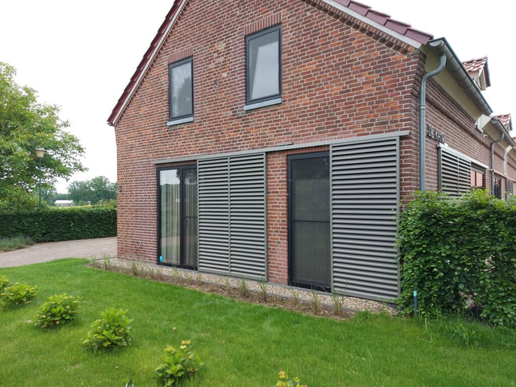 Klassieke woning met schuifpanelen met vaste lamellen aan de gevel