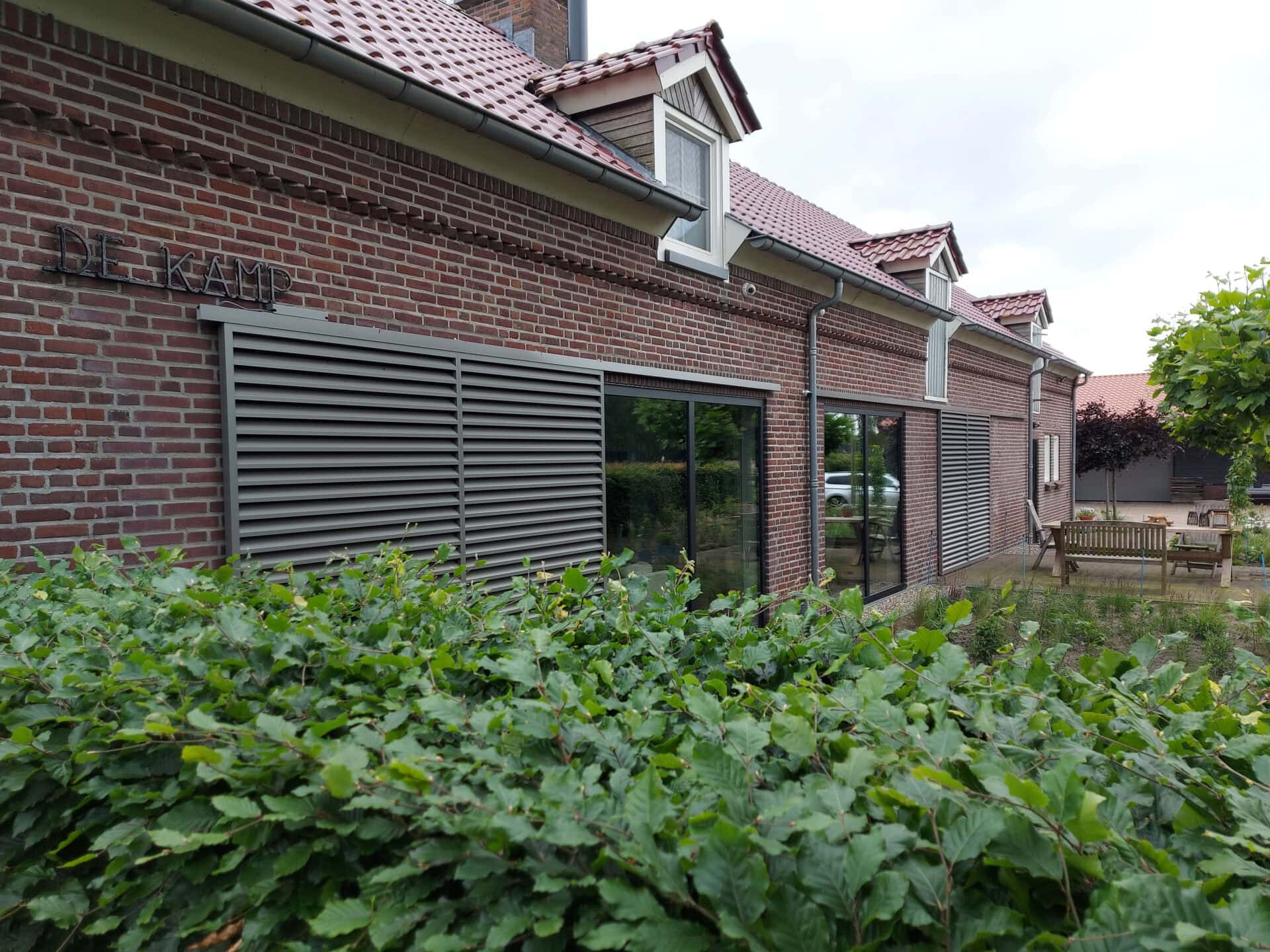 Klassieke woning met schuifpanelen met vaste lamellen aan de gevel, voor het raam