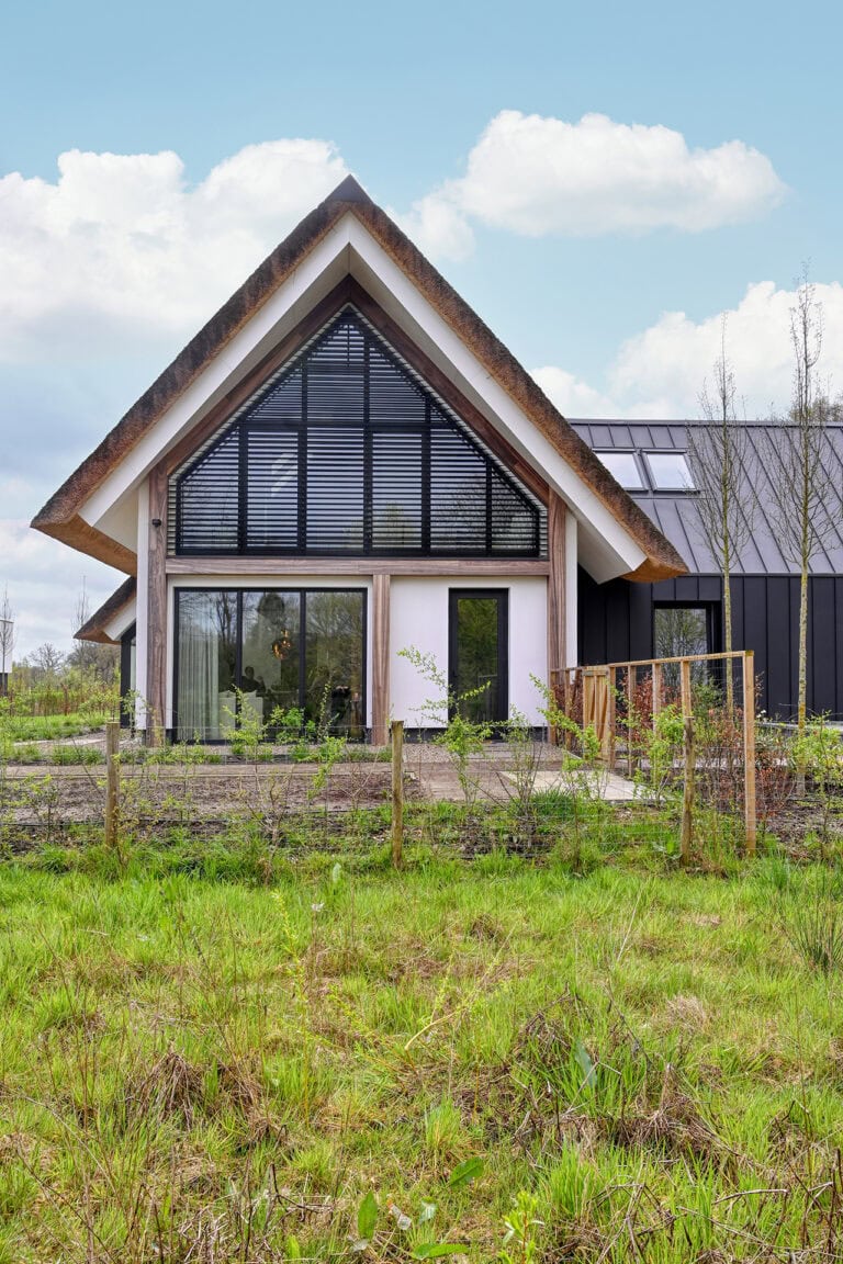 Villa met strodak en kantelbare lamellen in puntgevel