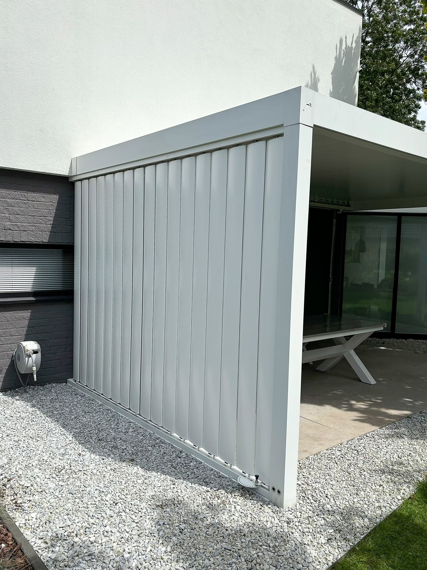 Terrasoverkapping met verticale lamellen aan de zijkant in gesloten stand