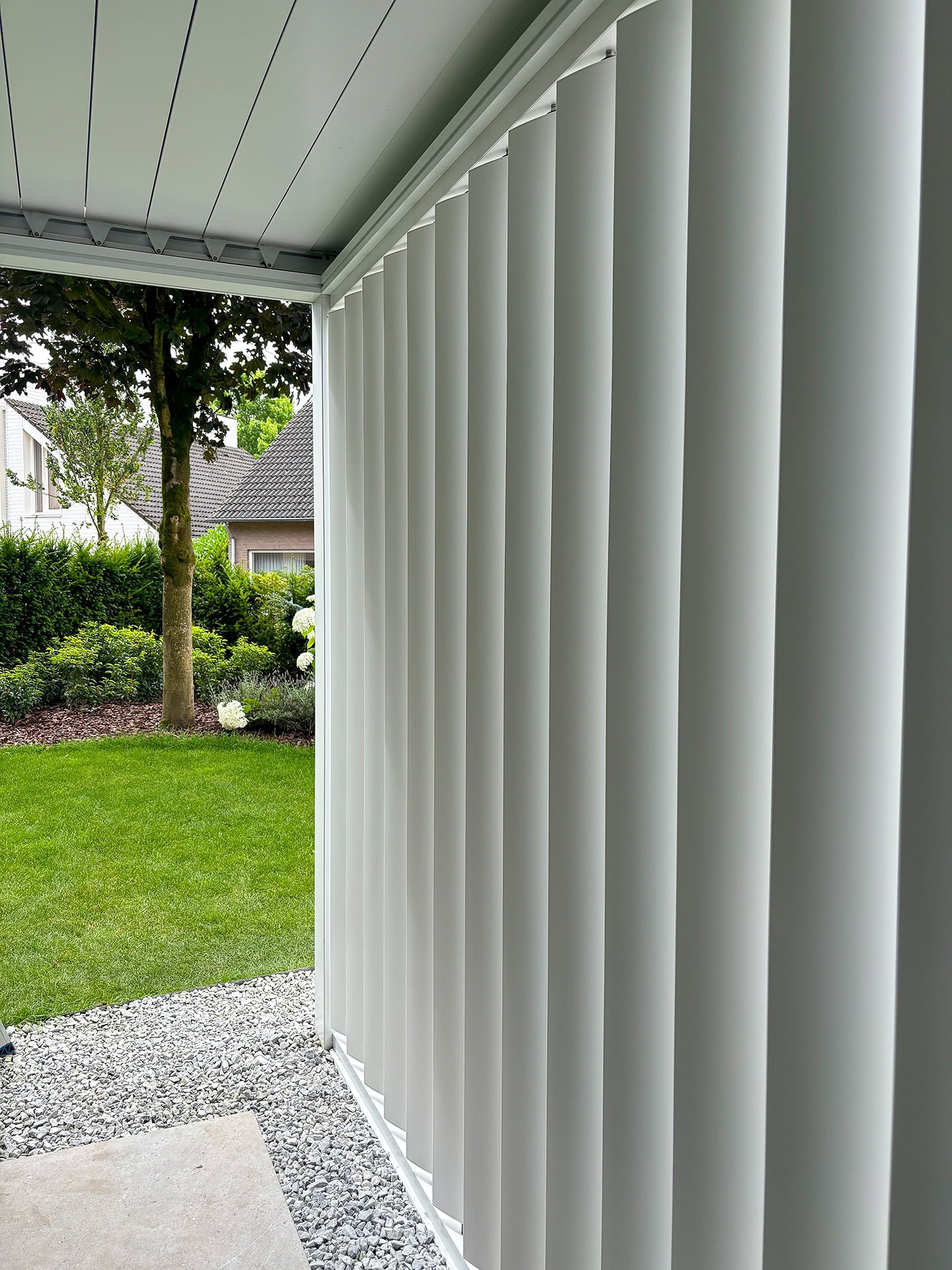 Close-up van verticale lamellenwand bij een terrasoverkapping