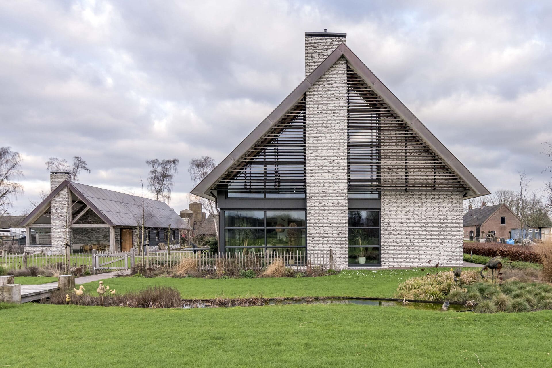 Landelijke woning met houten lamellen in open stand in driehoek