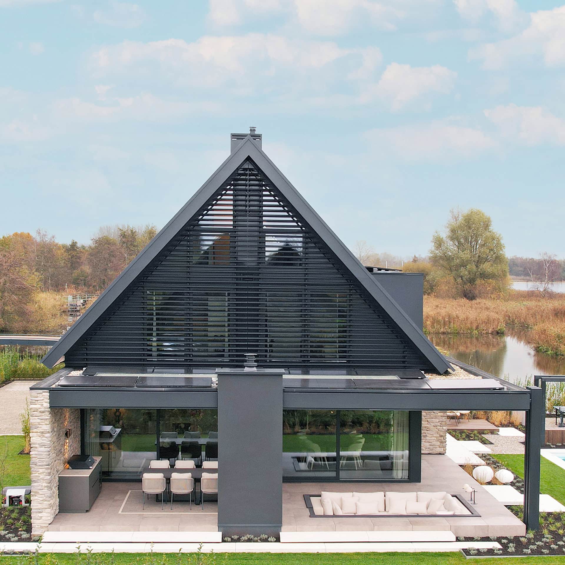 De volledige topgevel van deze moderne woning is voorzien van kantelbare lamellen