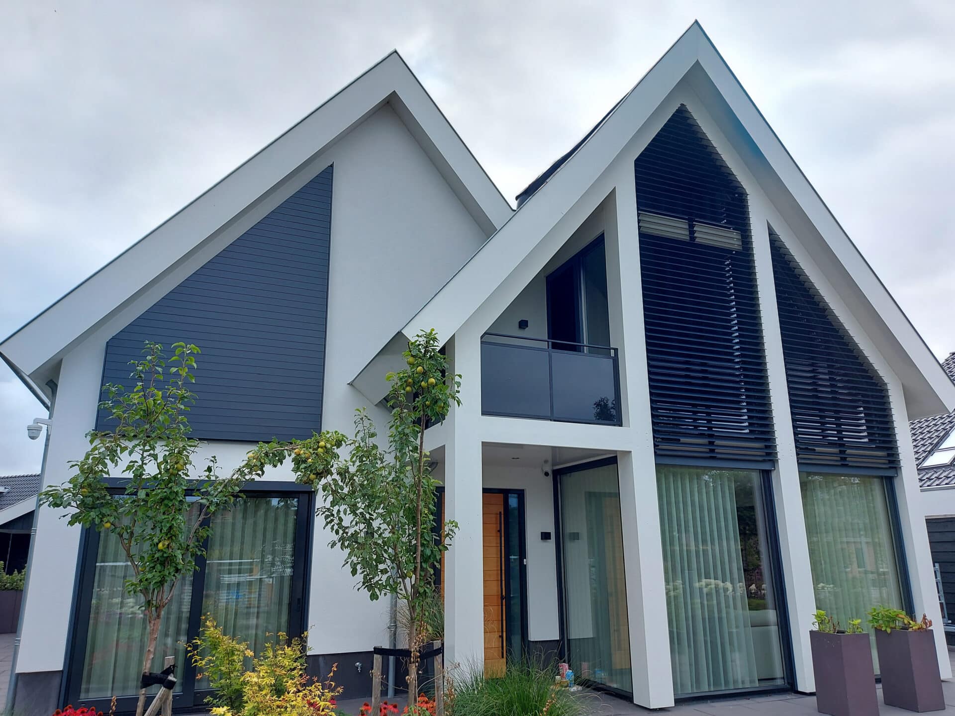 Villa met verschillende kantelbare lamellensystemen in driehoekramen