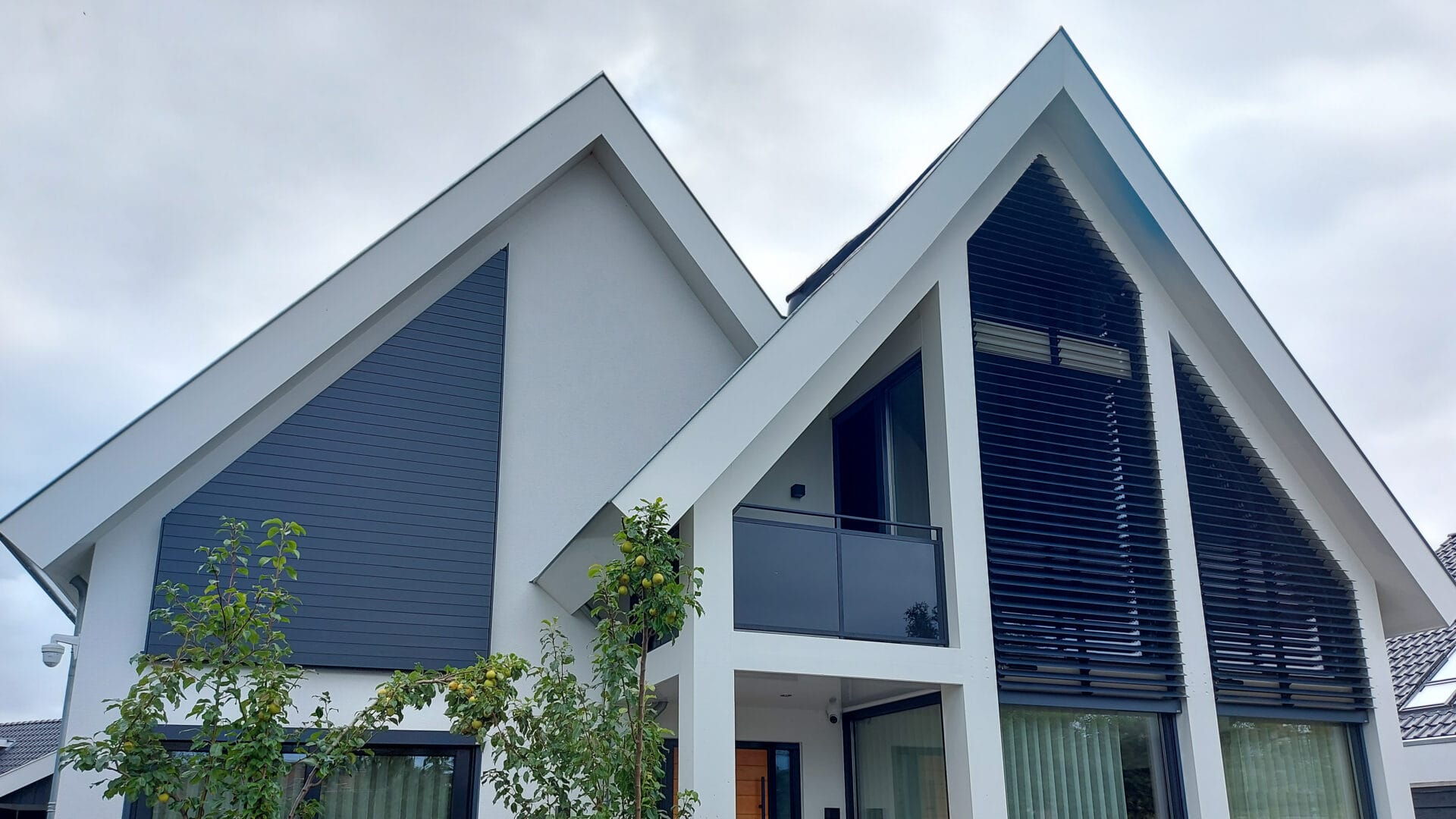 Villa met verschillende kantelbare lamellensystemen in driehoekramen