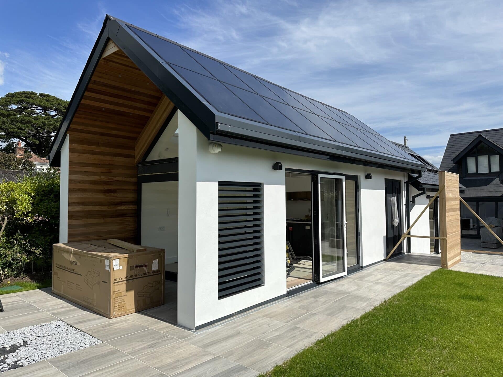 Volledig aanzicht van het tuinhuis met kantelbare lamellenwand