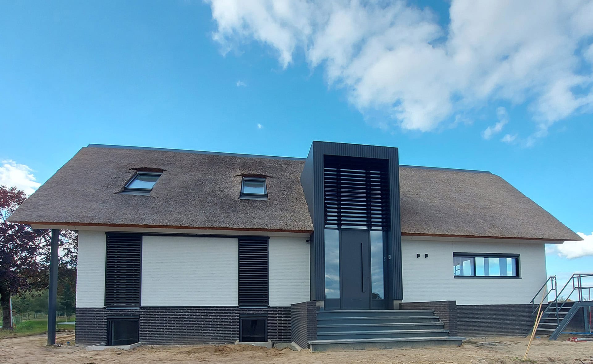 Moderne woonboerderij met kantelbare lamellen in een risaliet en schuifpanelen aan de voorzijde