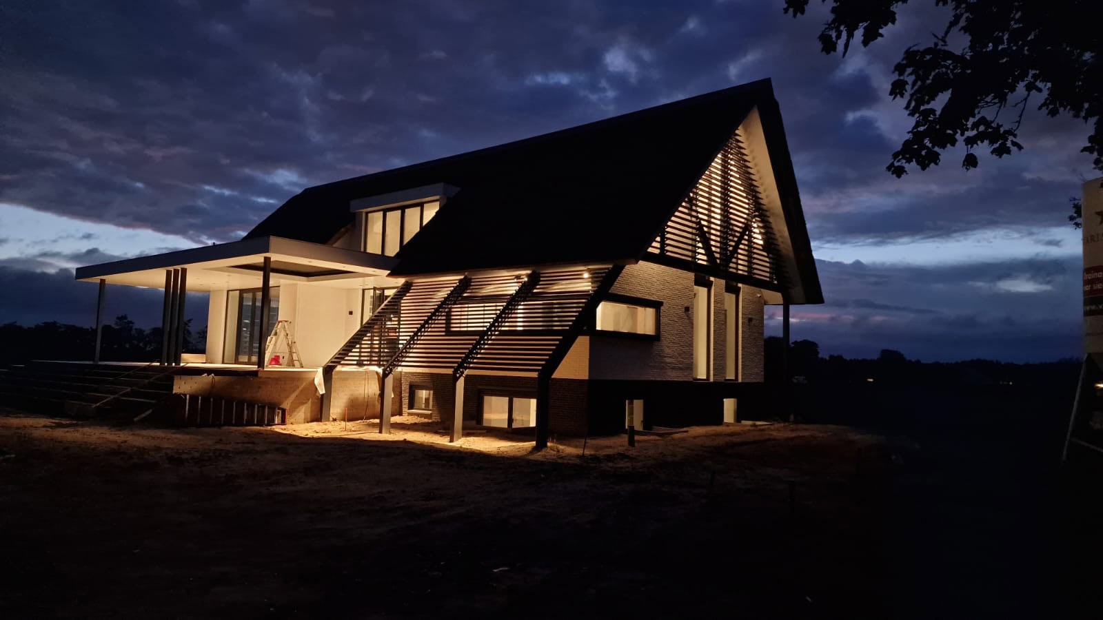 Moderne woonboerderij in de nacht met kantelbare lamellensystemen