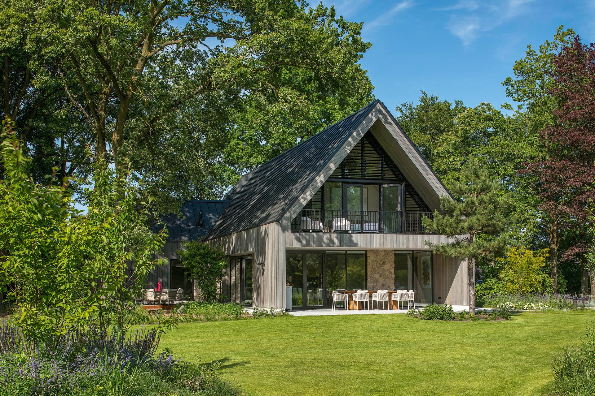 Landelijke woning met kantelbare lamellen in een puntraam