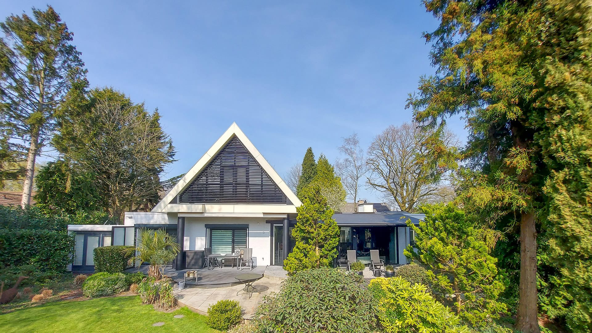 Kantelbare lamellen in grote driehoek aan de achtergevel