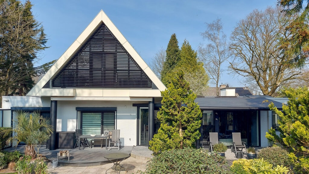 Kantelbare lamellen in grote driehoek aan de achtergevel