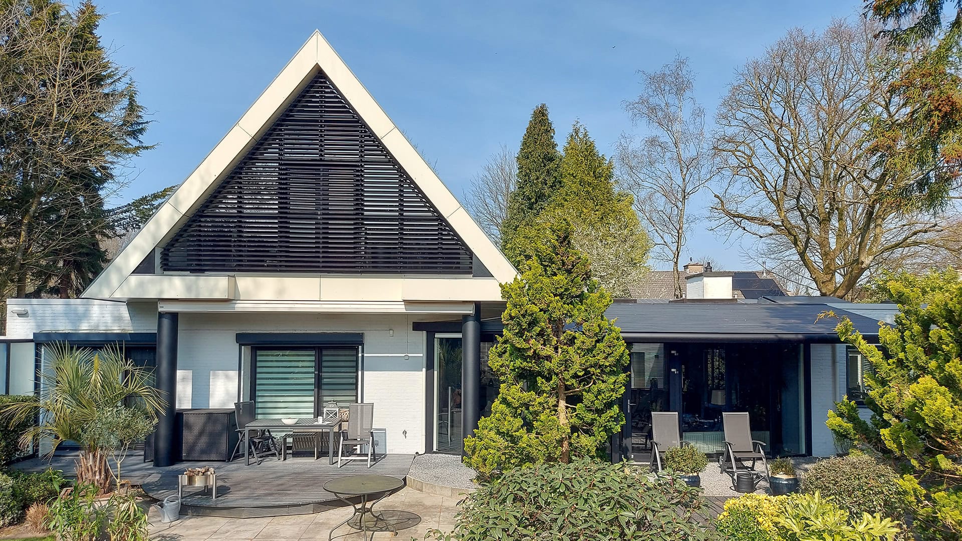 Kantelbare lamellen in grote driehoek aan de achtergevel