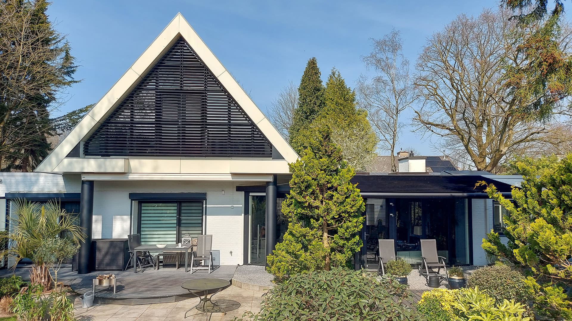 Kantelbare lamellen in grote driehoek aan de achtergevel