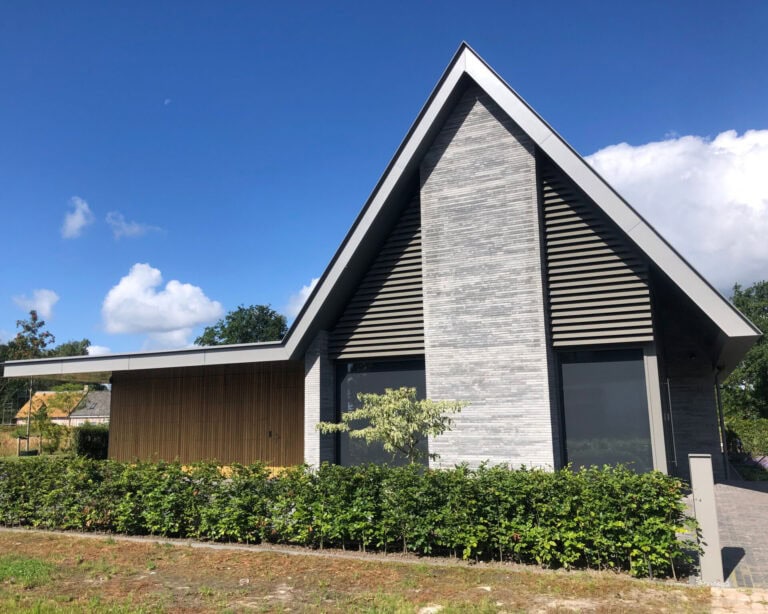 Trapezia in kwartsgrijs harmoniëren met gevelsteen van residentie in Gilze en Rijen